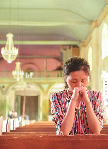 istock young girl praying in church 178461462