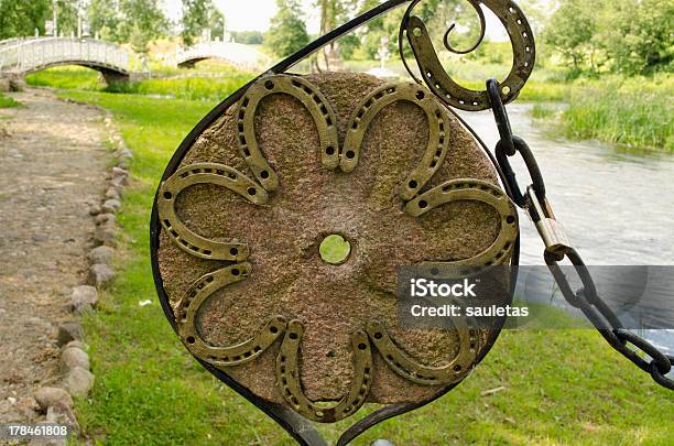 Photo libre de droit de Chaussure De Cheval Sur Old Meule Et Chaîne À Park banque d'images et plus d'images libres de droit de Décoration de fête - Décoration de fête, Fer à cheval, Prise de vue en extérieur