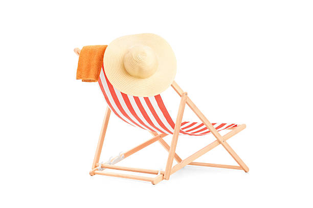 Towel and hat on a sun lounger with stripes Towel and hat on a sun lounger with stripes, isolated on white background deck chair stock pictures, royalty-free photos & images
