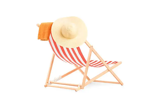 Photo of Towel and hat on a sun lounger with stripes