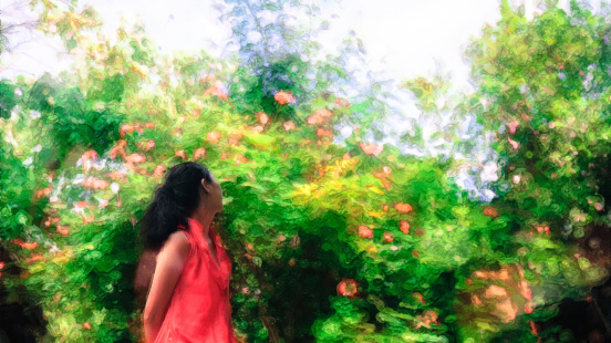 Back portrait of single young girl looking at the blossoming flowers and trees, post-processed and displayed in water painting style. Shot in Bee Farm, Panglao, Bohol, Philippines.