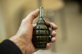 Grenade in hand. Training grenade. Explosives detonator.
