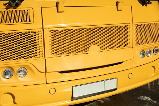 Yellow school bus. Details of school transport. Car headlights. Old public transport.