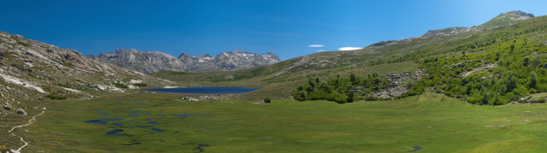 Panorama view of an altitude lake and meadows in Corsica, France