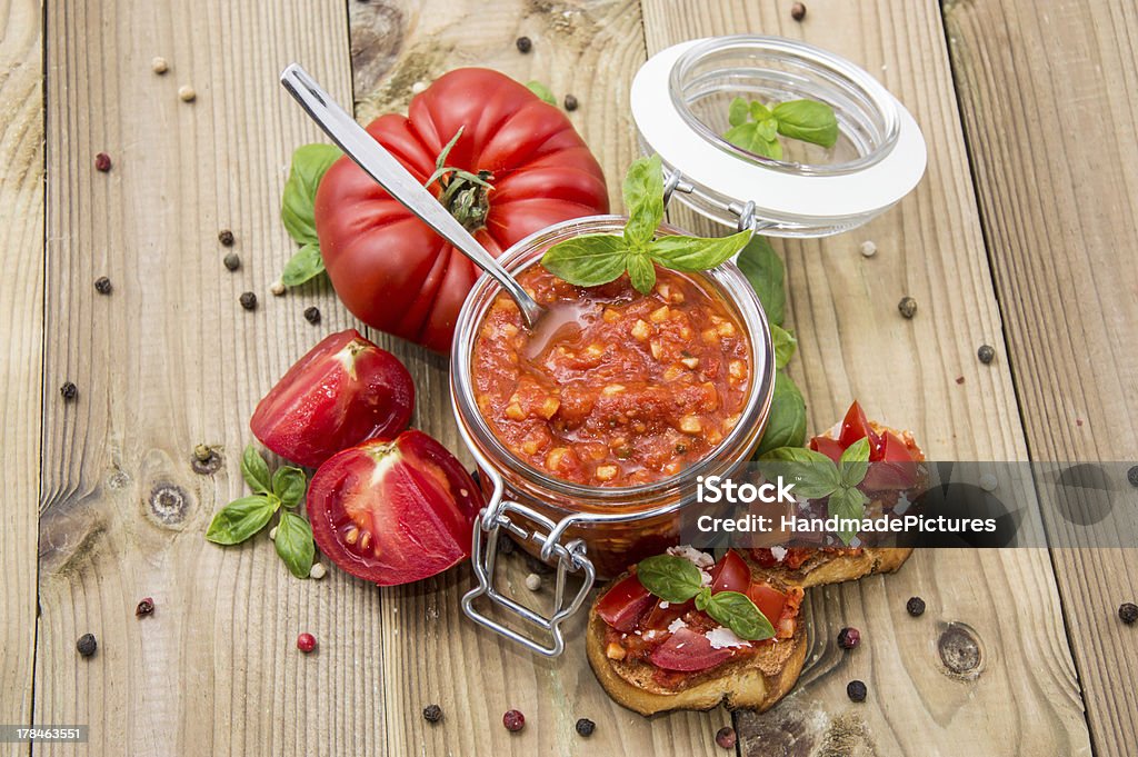 Fresh made Bruschetta Sauce Fresh made Bruschetta Sauce in a glass on wooden background Pesto Sauce Stock Photo