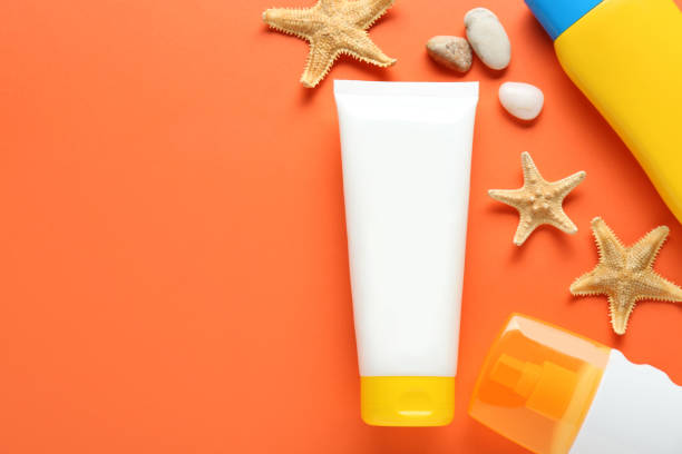 istock Suntan products and seashells on orange background, flat lay. Space for text 1784640530