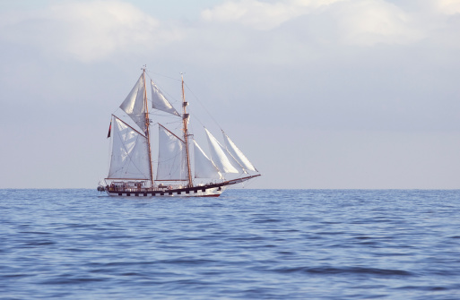 Ship with white sails in the calm sea