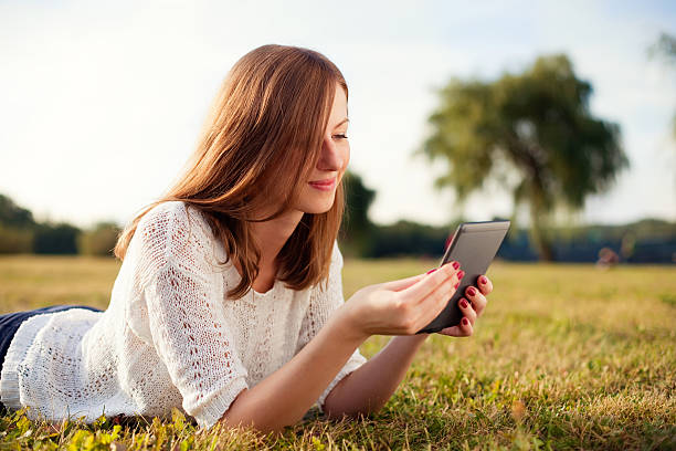 istock Beautiful young woman with digital tablet in park 178464271
