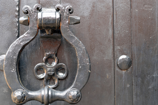 Vintage metal door handle. Ancient architecture background.
