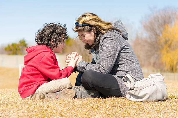 istock Single Mother and Son Praying Outdoors 178464740