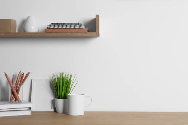 istock Comfortable workplace with wooden desk near white wall at home 1784655248