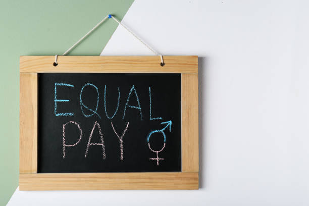 カラーウォールに「equal pay」とジェンダーシンボルが書かれた黒板。テキスト用のスペース - sex object ストックフォトと画像