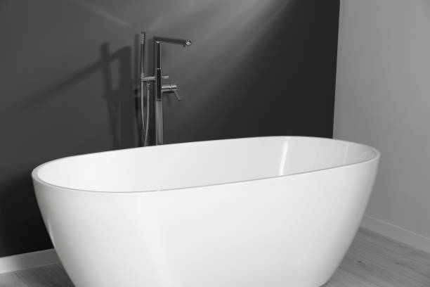 istock Stylish ceramic tub near grey wall in bathroom 1784656290
