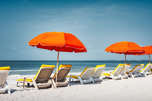 Beach with Lounge Chairs and Umbrella in Fort Myers, Florida, USA on a sunny day.