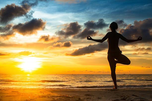 istock Girl practicing yoga by the sea at sunset. 178467577