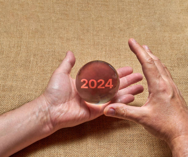 des mains tenant une boule de cristal, imaginant l’avenir de l’année 2024 - transparent crystal crystal ball human hand photos et images de collection