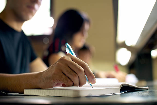 maschio studente facendo i compiti in biblioteca - library student latin american and hispanic ethnicity university foto e immagini stock