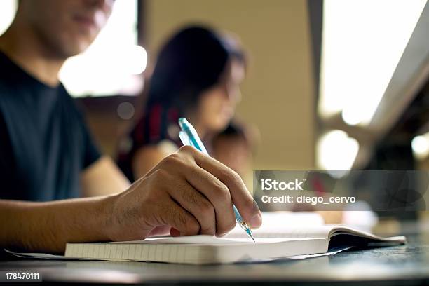 Male Student Doing Homework At Library Stock Photo - Download Image Now - Writing - Activity, Adult, Studying