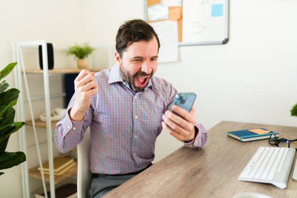 istock Exxited caucasian boss celebrating good news at work using his phone 1784704554