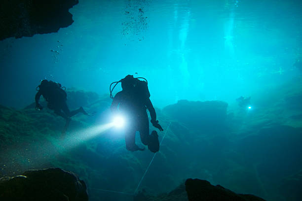 Underwater scuba divers in a cenote stock photo