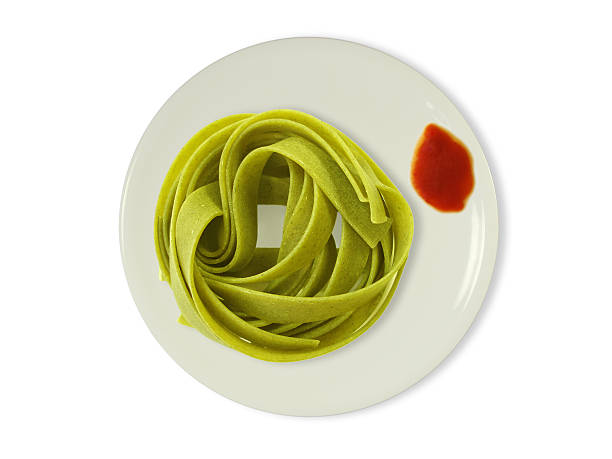 grüne bandnudeln auf teller mit tomatensoße - teigwaren foto e immagini stock