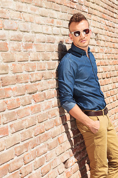 istock casual man hands in pockets by wall 178472915