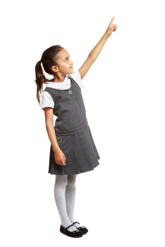 8 year old school girl pointing up smiling on white background