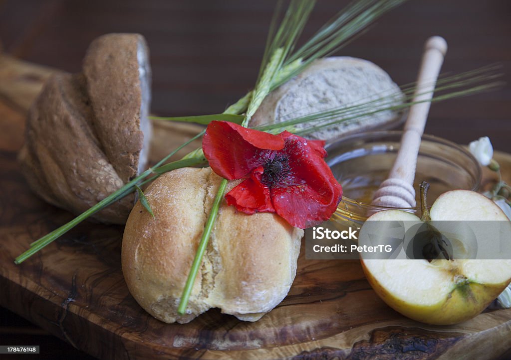 Tasty organic rolls and bread with honey Tasty organic rolls, buns and acacia honey in glass bowl with wooden drizzler, served on olive tree plate, selective focusFresh baked bread and acacia honey in glass bowl with wooden drizzler, served on olive tree plate with bio Topaz apple, selective focus Acacia Tree Stock Photo
