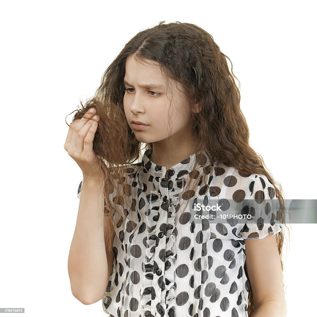 sad schoolgirl unhappy with her hair Beautiful sad schoolgirl unhappy with her hair, isolated on white background. Curly Hair Stock Photo