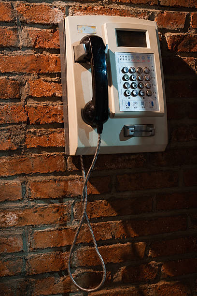 paiement téléphone sur le mur de brique rouge - pay phone brick wall telephone old photos et images de collection