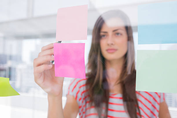 istock Young woman pointing sticky note with her pen 178478379
