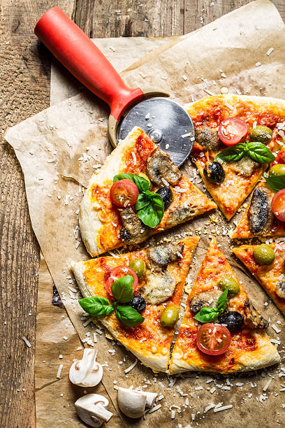 istock Cutting homemade pizza on old table 178479772