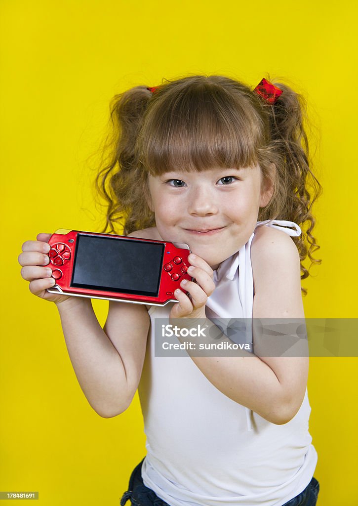 遊ぶ少女ハンドヘルドポータブルゲームコンソール - 6歳から7歳のロイヤリティフリーストックフォト