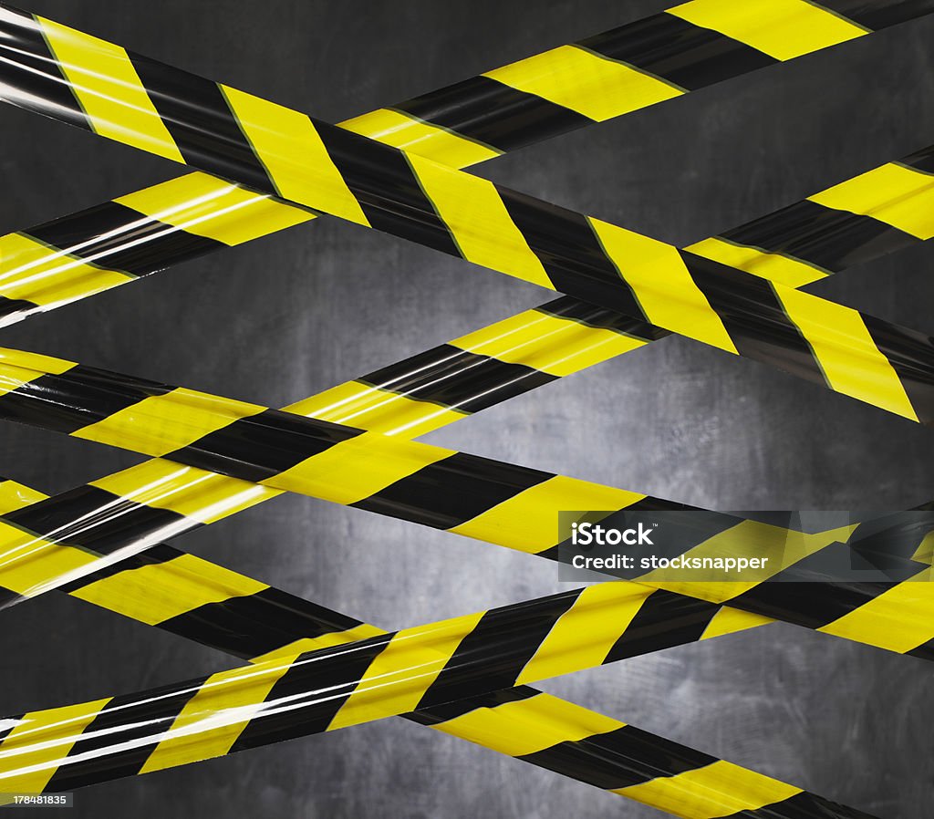 Don't Go There! Black and yellow plastic barrier tape blocking the way. Barricade Tape Stock Photo