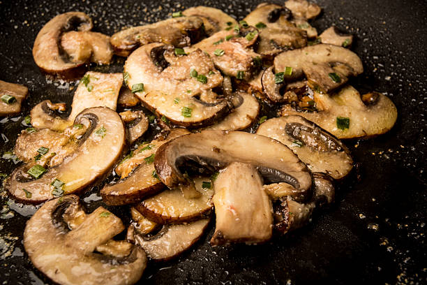 Frying Mushrooms In Saute Pan Frying Mushrooms In Saute Pan sauteed stock pictures, royalty-free photos & images