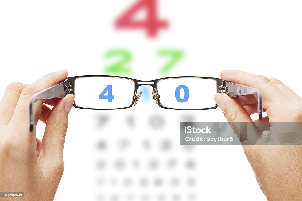 Looking through the glasses at eye chart Human hands holding eyeglasses with eye chart in the back Assistance Stock Photo