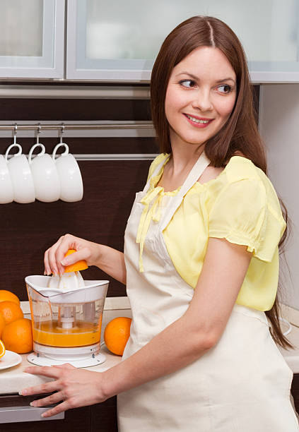 美しい女性をオレンジジュース - stereotypical housewife women domestic kitchen brown hair ストックフォトと画像