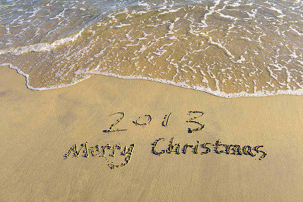 frohe weihnachten 2013 nachricht auf dem sand beach - 2013 beach new years eve new years day stock-fotos und bilder