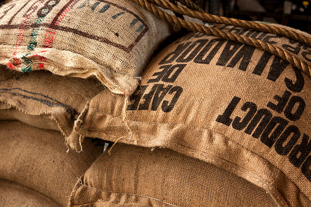 plastiksäcken mit kaffeebohnen - coffee sack bag warehouse stock-fotos und bilder
