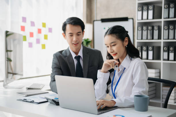 istock Asian business colleague business presents and explains and using laptop and tablet. Teamwork, financial marketing team, while sitting in office room. 1784860336