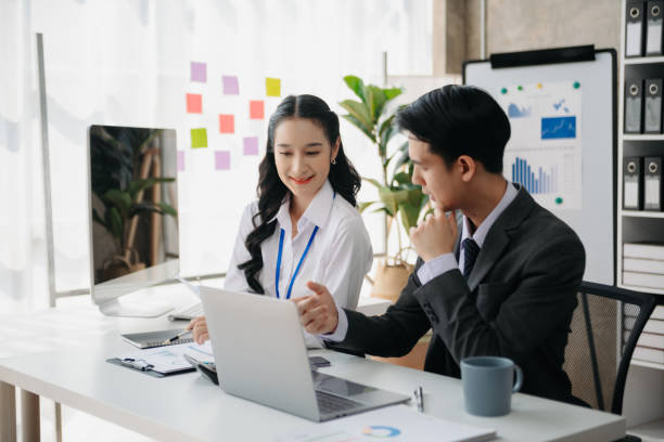 istock Asian business colleague business presents and explains and using laptop and tablet. Teamwork, financial marketing team, while sitting in office room. 1784860338
