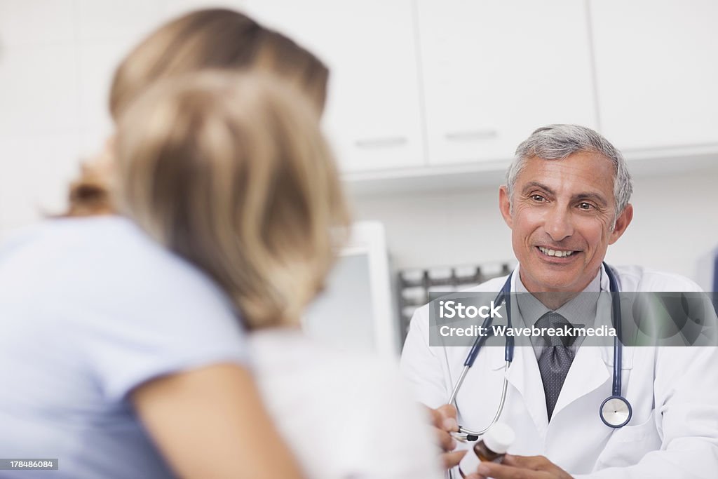 Doctor holding a drug box Doctor holding a drug box in a medical office 30-39 Years Stock Photo