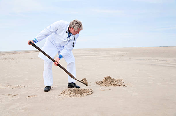 Doctor digging Hole with a Spade stock photo