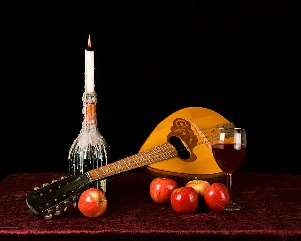 a horizontal image of a Russian balalaika and apples on a table