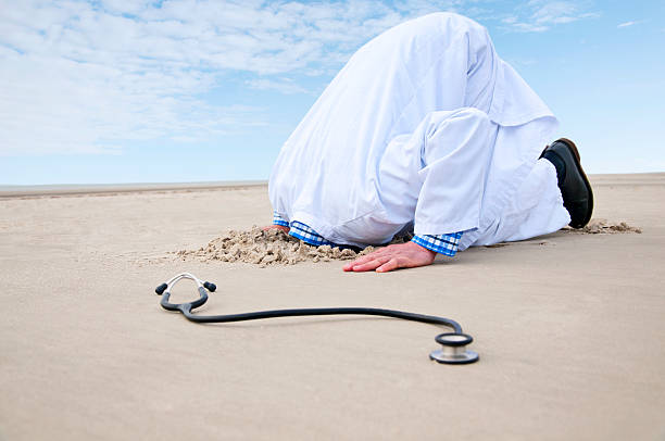 médico esconder a cabeça na areia - overstrained imagens e fotografias de stock