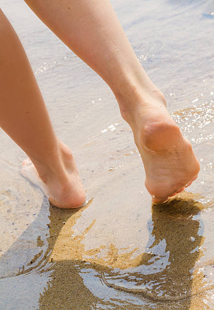 istock young woman take a walk on wet seashore 178487136