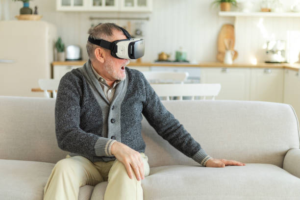 istock Excited mature senior man wearing using virtual reality metaverse VR glasses headset at home. Grandfather touching air during VR experience on virtual reality helmet. Simulation hi-tech videogame. 1784876969