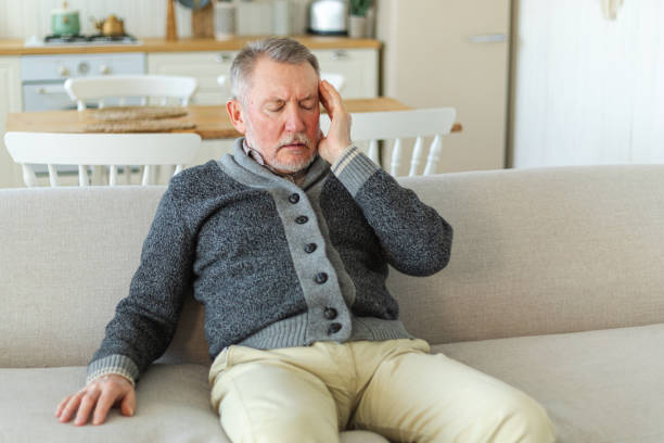 istock Headache pain. Unhappy middle aged senior man suffering from headache sick rubbing temples at home. Mature old senior grandfather touching temples experiencing stress. Man feeling pain hurt in head. 1784876975