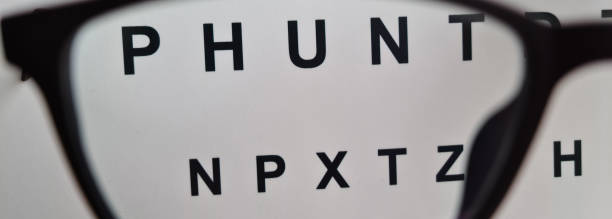istock Optometry looking through glasses at eye examination card 1784876978