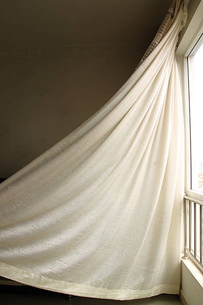 istock White curtain blown inward by strong breeze towards wall 178487803